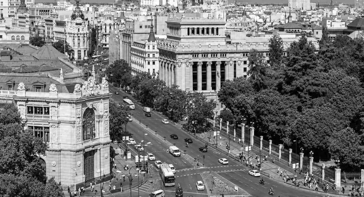Madrid desde el Palacio de Cibeles: la calle de Alcalá subiendo junto al Banco de España, con la ciudad al fondo. Blanco y negro.